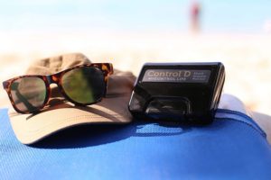 Sunglasses on a brown hat next to a Control D package | Featured image for The Vicious Cycle Between Poor Sleep and Diabetes.