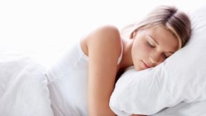 Blonde haired woman sleeping on a pillow | Featured image for What is healthy sleep? blog from Wenatex.