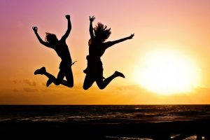 People jumping on a beach with the sun in the background | Featured image for The Power of Sleep blog from Wenatex.