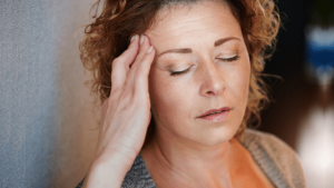 Woman rubbing her temple | Sleep For A Powerful Brain blog on Wenatex.