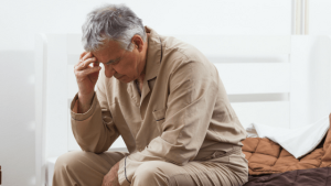 Man holding his temple | Featured image for Ageing and Sleep.