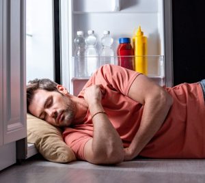 Man in orange tee shirt sleeping with their head in a refrigerator | Featured image for Why is temperature so important?