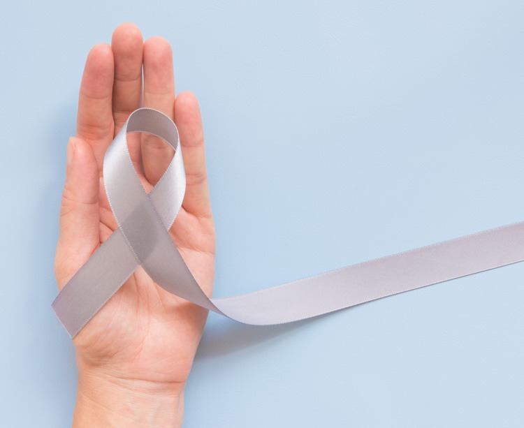 Photo of a white ribbon in the palm of hand to celebrate Parkinsons Awareness Day | Featured image for Parkinson's Awareness Month.