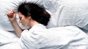 Young Woman Sleeping on Side | Featured image for Wenatex’s Seasonal Sleep Patterns Blog.