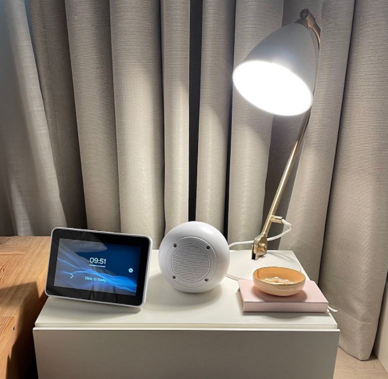 SleepHub device resting on a nightstand next to a lamp | bellaMUMMA sleep school blog post featured image.