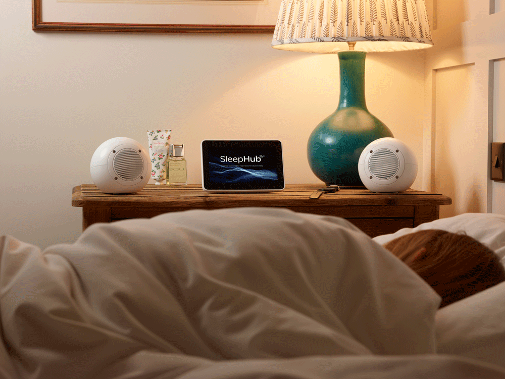 The SleepHub device on a bedside nightstand.