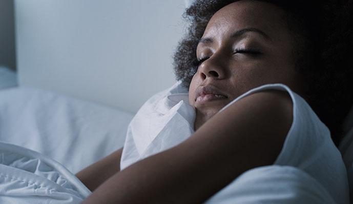 A woman sleeping soundly in her bed.