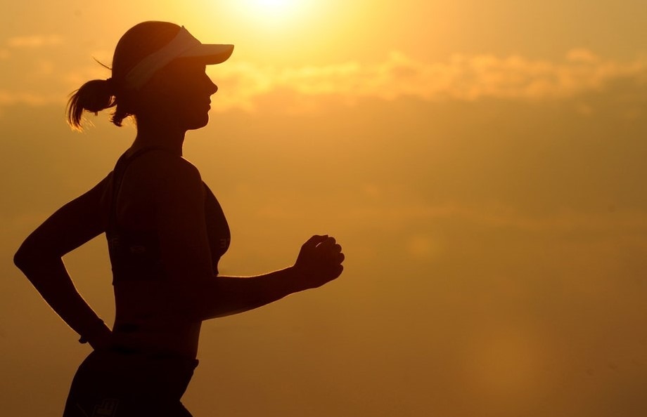 A female jogger jogging in the sunset.