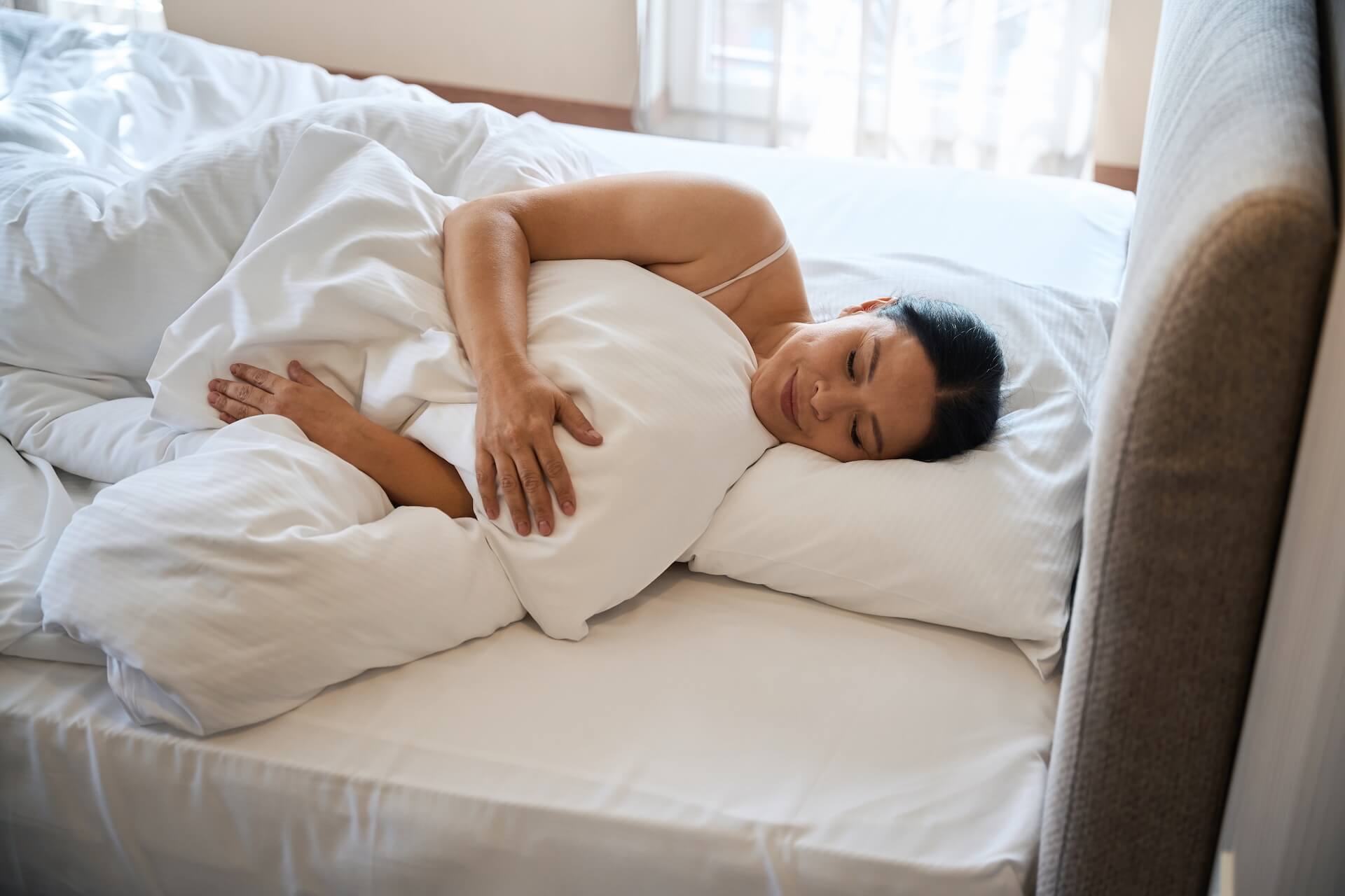 Woman sleeping peacefully | Featured image for Light Stage of Sleep Blog on SleepHub.